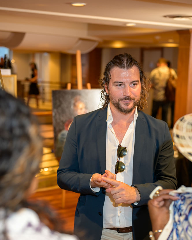 Alex Righetto in conversazione con un collezionista 3 Alex Righetto conversa con un collezionista a proposito delle sue opere durante l’Art & Luxury Monaco 2026, al Théâtre Princesse Grace di Monaco.