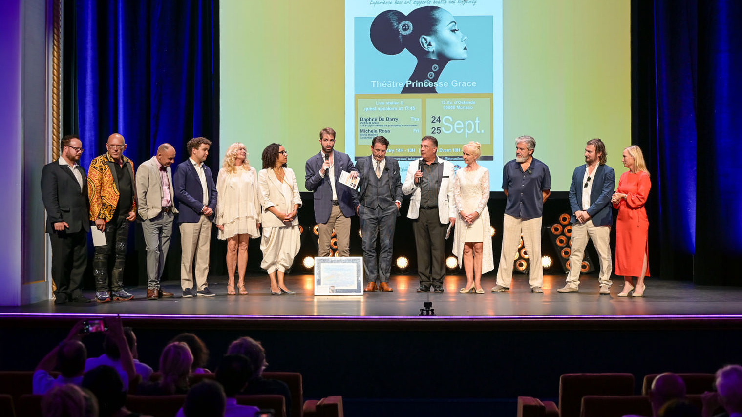 Foto della Fiera d’Arte e Lusso durante il Monaco Yacht Show 3 Alex Righetto sul palco dell’Art & Luxury Monaco 2026 insieme alla Principessa Margherita de Bourbon de Parme e all’organizzatrice dell’evento Annette, al Théâtre Princesse Grace.
