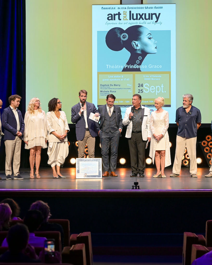 Alex Righetto sul palco dell’Art & Luxury Monaco 2026 insieme alla Principessa Margherita de Bourbon de Parme e all’organizzatrice dell’evento Annette, al Théâtre Princesse Grace.